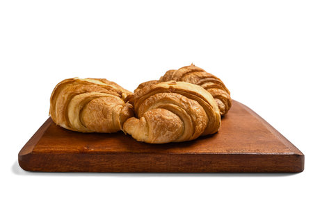 Freshly baked croissants on a wooden tray isolated over a white backgroundの写真素材