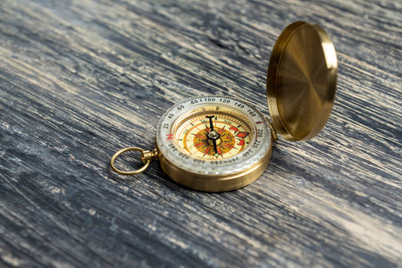 Closeup view of navigational compass on wooden background. Travel guidance equipment