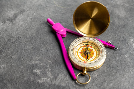 Closeup view of navigational compass and pink compasses on a black background. Travel guidance equipmentの写真素材