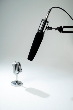 Studio microphone for podcasting or streaming on a boom arm with a vintage classic mic on a white backgroundの写真素材