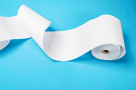 Roll of thermal paper for a receipt on a blue background. Copy spaceの写真素材