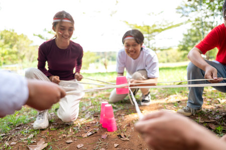 Portrait of an Indonesian southeast asian people celebrate Indonesia Independence Day on the 17th of August with a game of building a plastic glass stack with a stick outdoors. Concept of Kemerdekaan Indonesiaの写真素材