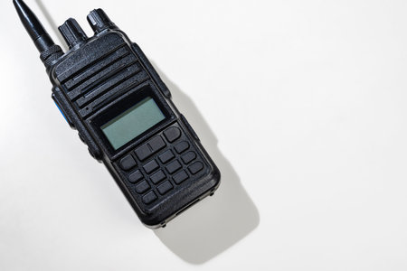 Closeup view of a black walkie talkie radio communication device isolated over a white backgroundの写真素材