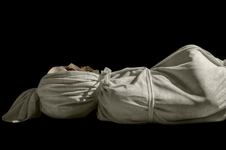 Pocongs on a black background. A traditional ghost from Indonesia that takes the form of a human wrapped in a shroud or winding sheet. Concept of Halloweenの写真素材