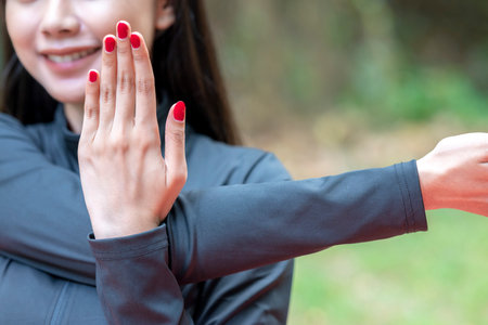 Indonesian southeast asian woman in a sporty outfit practices exercise in a public park outdoors. Concept of a Healthy active lifestyleの写真素材