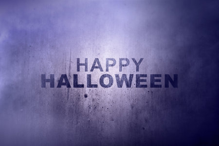 Dust and smoke with the text of Happy Halloween on the wall background. Concept of Happy Halloweenの写真素材