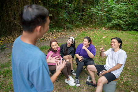 Indonesian southeast asian people in a sporty outfit conversation or discussion together after practice exercise in a public park outdoors. Concept of a Healthy active lifestyleの写真素材