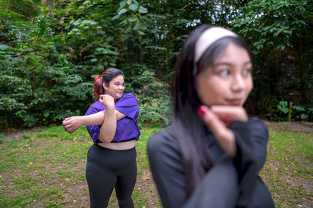 Indonesian southeast asian women in a sporty outfit practice exercise in a public park outdoors. Concept of a healthy active lifestyleの写真素材