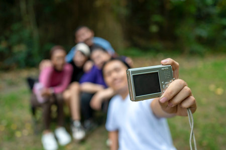 Southeast asian people in a sporty outfit taking a selfie with a camera together after practice exercise in a public park outdoors. Concept of a Healthy active lifestyleの写真素材