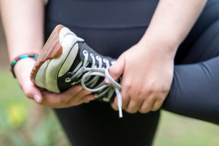 Overweight woman in a sporty outfit practices exercise in a public park outdoors. Concept of a Healthy active lifestyle and body inclusivityの写真素材
