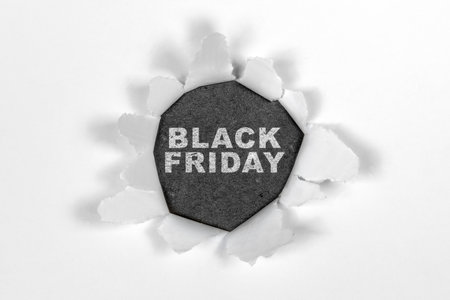 Top view of white ripped paper and text of Black Friday on a black background. Copy space. Flat lay. Black Friday sale conceptの写真素材