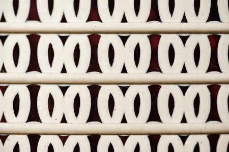 Closeup detail of a horizontal pattern comprised of parallel lines interspersed with repeating oval shapes against a contrasting dark background. Geometric textures backgroundの写真素材