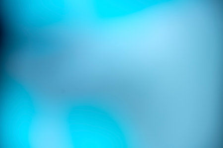 Smooth and blurry gradient background featuring a blend of blue and turquoise, creating a vibrant...