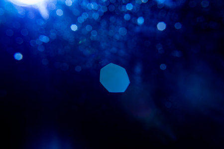 Abstract background featuring soft, dark blue bokeh lights. Decorative element suitable for use as a backdropの写真素材