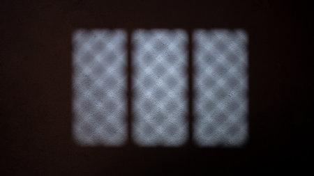 Blurry view of the dramatic shadow of the window light casting on the wall. Copy space. Textured backgroundの写真素材