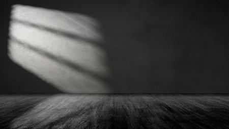 Striking light beam shines across the interior of the room with concrete walls and a wooden floor. Mockup, copy space, or template. Empty backdrop podium for product or text displayの写真素材