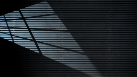 Dramatic shadow of window light casting on the striped wall texture. Copy space. Textured backgroundの写真素材