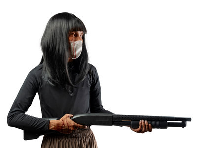 Indonesian southeast asian transgender man dressed as a woman wearing a bloody face mask and holding a shotgun isolated over a white background. Concept of Halloween, Sister Hong, or red uncleの写真素材