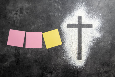 Christian cross formed by a dusting of white powder with a row of notes on the table. Mockup or Copy space. Concept of Christianity, religious, faith, Jesus, or beliefの写真素材