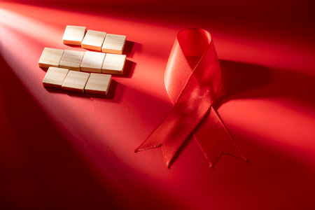 Red ribbon on a red background. Symbolizing awareness and support for HIV or AIDS patients. World Aids Day. Concept of Healthcare and Medicineの写真素材
