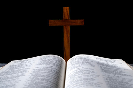 Blue book of the Holy bible and Christian cross. Standing on the table with a dark background. Symbol of faith in God. Concept of Spirituality, Christianity, religion, faith, Jesus, or beliefの写真素材