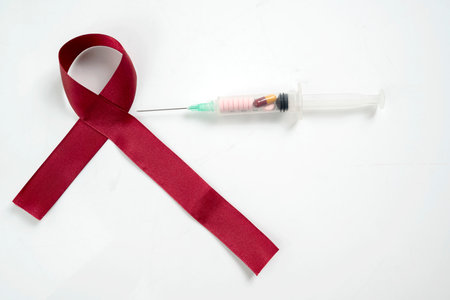 Red ribbon and syringe on a white background. Symbolizing awareness and support for HIV or AIDS...