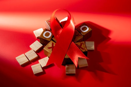 Red ribbon on a red background. Symbolizing awareness and support for HIV or AIDS patients. World Aids Day. Concept of Healthcare and Medicineの写真素材