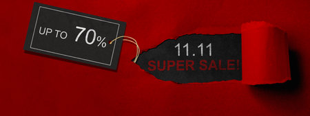 Top view of red ripped paper and text of 11.11 super sale with up to 70% text on the label tag. Copy space. Flash sale conceptの写真素材
