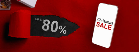 Christmas sale text on cellphone screen and Christmas ornament on giftbox with up to 80% text on the label tag. Copy space. Christmas sale conceptの写真素材