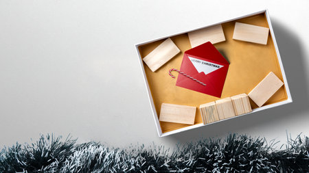 Greeting of Merry Christmas text with a wooden block and a candy cane in a giftbox. Mockup or Copy space. Holiday greetings or winter themes. Concept of the Merry Christmas celebrationの写真素材