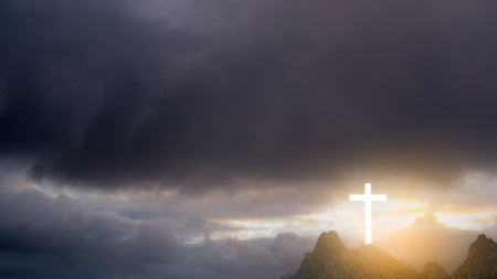 Light of the Christian cross on the hill with dark dramatic sky background. Concept of Christianity, religious, faith, Jesus, or beliefの写真素材
