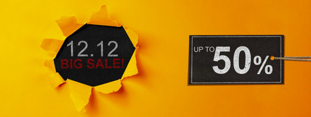 Top view of yellow ripped paper and text of 12.12 big sale with up to 50% text on the label tag. Copy space. Flash sale conceptの写真素材