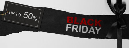 Top view of white ripped paper and text of Black Friday with up to 50% text on the label tag. Copy space. Flat lay. Black Friday sale conceptの写真素材