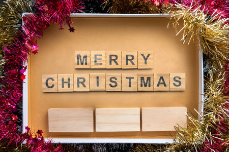 Greeting of Merry Christmas text with a wooden block in a giftbox. Mockup or Copy space. Holiday greetings or winter themes. Concept of the Merry Christmas celebrationの写真素材