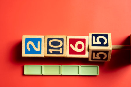 Row of wooden number blocks with various numbers and lime rectangular blocks on colored background....
