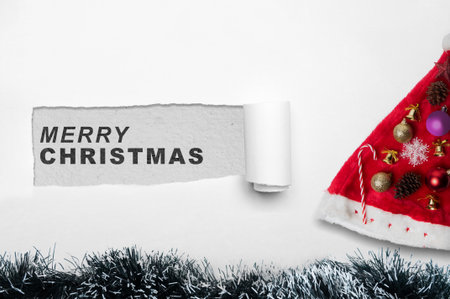 Greeting of Merry Christmas text on ripped paper. Mockup or Copy space. Holiday greetings or winter themes. Concept of the Merry Christmas celebrationの写真素材