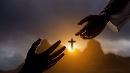 Jesus Christ hand offering a helping hand with Christian cross on the hill with dark dramatic sky background. Concept of Christianity, religious, faith, Jesus, or beliefの写真素材