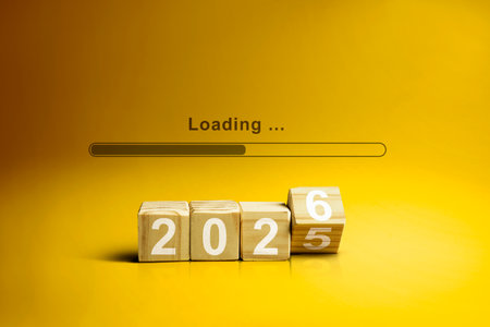 Loading bar with wooden cubes transform from the number 2025 to 2026 on a yellow background. New Year concept or Celebrationの写真素材