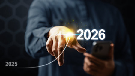 Business hand with cellphone slides the ascending line from 2025 to 2026 on a virtual screen. Happy...