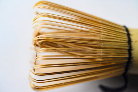 High-angle macro shot of a traditional Japanese bamboo matcha whisk, showing intricate details of the tines and central core. Ideal for tea ceremony and wellness contentの写真素材