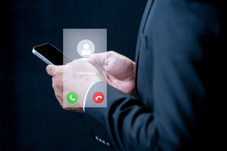 A businessman in a suit holds a smartphone featuring a digital interface for an unknown incoming call. Concept of privacy, communication, and digital securityの写真素材