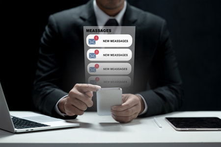 Professional businessman in a suit using a smartphone with virtual message notifications and alerts appearing. Concept of digital communication, technology, and business productivityの写真素材