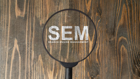 A magnifying glass highlighting the acronym SEM and Search Engine Management text on a rustic wooden surface. Concept for digital marketing strategy and SEO optimizationの写真素材