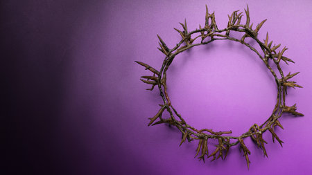 Symbolic crown of thorns placed on a textured purple surface with a soft gradient. Perfect for religious themes like Holy Week, Good Friday, and the Passion of Christ. Includes copy space for textの写真素材