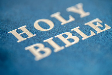 Detailed macro shot of the embossed 'HOLY BIBLE' text in silver on a textured blue leather-bound book cover. Shallow depth of field highlights the sacred scripture titleの写真素材