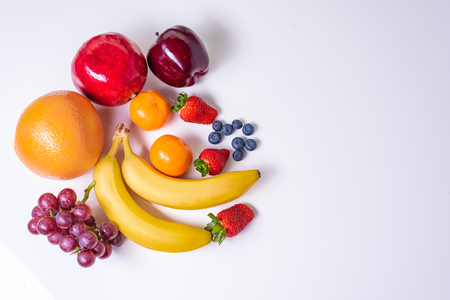 Various fruits arranged in white table top with copy space.の写真素材