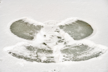 Angel figure in the snow made by a kid in a frozen lake one cold winter day.の写真素材