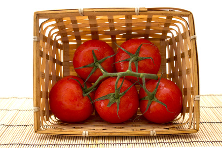 a basket of tomatoes with a sprig on white background. healthy foodの写真素材