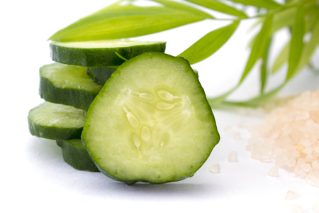 Slices of cucumber with sea salt isolated on white backgroundの写真素材