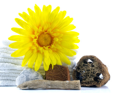 Spa and wellness setting with towel, gerbera, wooden parts, natural loofah sponge on a white background with clipping pathの写真素材